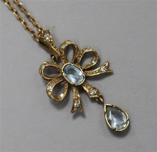 An 18ct gold, aquamarine and diamond openwork tied ribbon pendant on 18ct fine gold chain